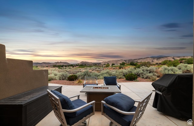 5048 N Escapes Dr, St George, UT 84770 - patio terrace at dusk featuring a patio area, a mountain view, a grill, and a fire pit