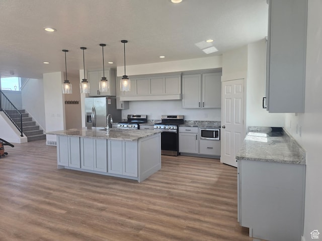 1573 N Woodside Dr, Spanish Fork, UT 84660 - kitchen with stainless steel appliances, light wood finished floors, recessed lighting, light stone countertops, and hanging light fixtures