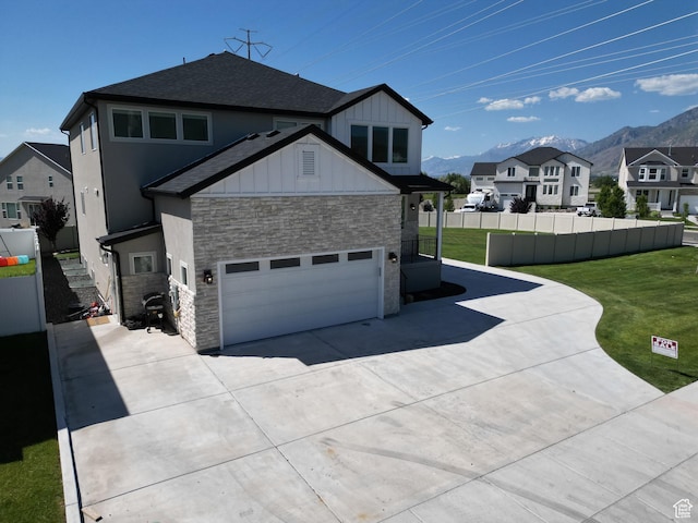 1573 N Woodside Dr, Spanish Fork, UT 84660 - view of side of property featuring stone siding, concrete driveway, a mountain view, roof with shingles, and a residential view