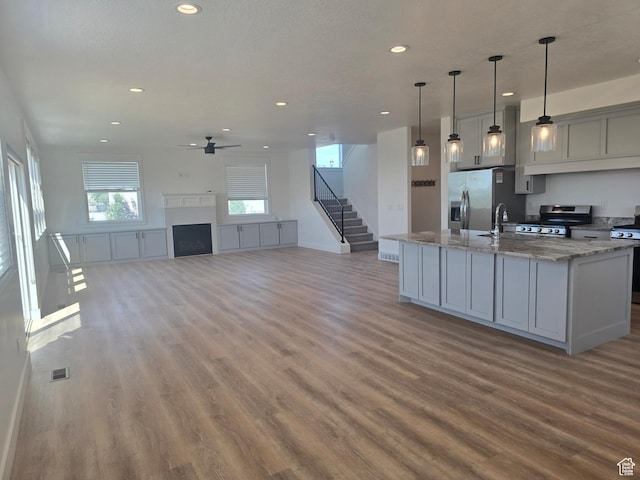 1573 N Woodside Dr, Spanish Fork, UT 84660 - kitchen with stainless steel appliances, wood finished floors, ceiling fan, recessed lighting, and light stone countertops