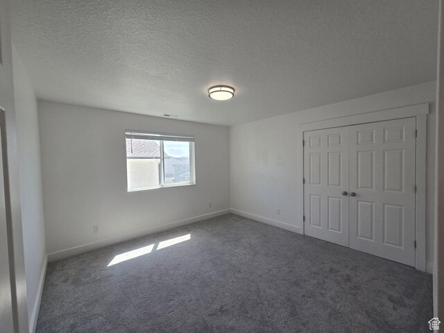 1573 N Woodside Dr, Spanish Fork, UT 84660 - unfurnished bedroom featuring carpet floors, baseboards, a textured ceiling, and a closet
