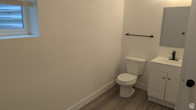 3065 S Brinker Ave, Ogden, UT 84403 - half bathroom with wood finished floors, toilet, vanity, and baseboards