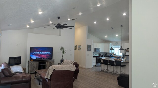 3065 S Brinker Ave, Ogden, UT 84403 - living room with light wood-style flooring, high vaulted ceiling, ceiling fan, and baseboards