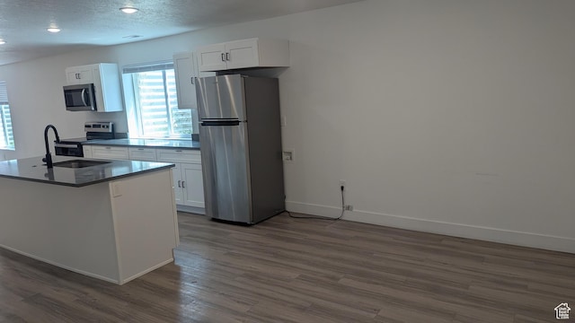 3065 S Brinker Ave, Ogden, UT 84403 - kitchen featuring appliances with stainless steel finishes, a sink, dark wood-type flooring, white cabinetry, and baseboards