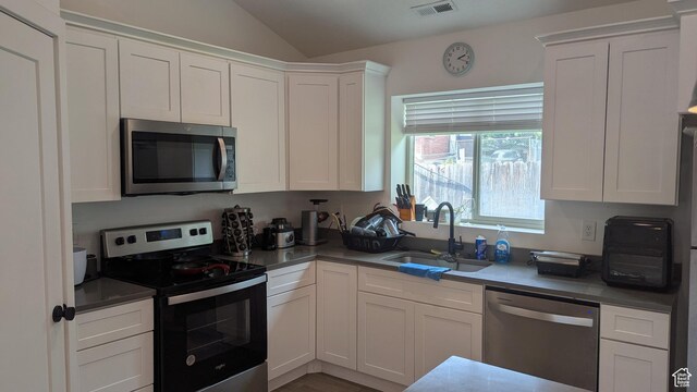 3065 S Brinker Ave, Ogden, UT 84403 - kitchen with stainless steel appliances, a sink, lofted ceiling, and white cabinetry