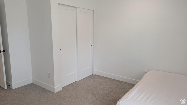 3065 S Brinker Ave, Ogden, UT 84403 - bedroom featuring light carpet, a closet, and baseboards