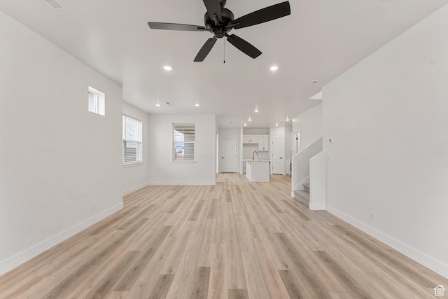 6134 S Kelly Ln, St George, UT 84790 - unfurnished living room featuring a ceiling fan, light wood finished floors, baseboards, stairway, and recessed lighting