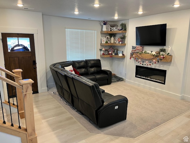 3198 N 3475 W, Plain City, UT 84404 - living room featuring a glass covered fireplace, light wood-style floors, baseboards, and stairs