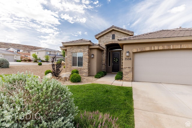 3504 E 3140 S, St George, UT 84790 - view of front facade featuring driveway, a garage, stucco siding, a tile roof, and stone siding