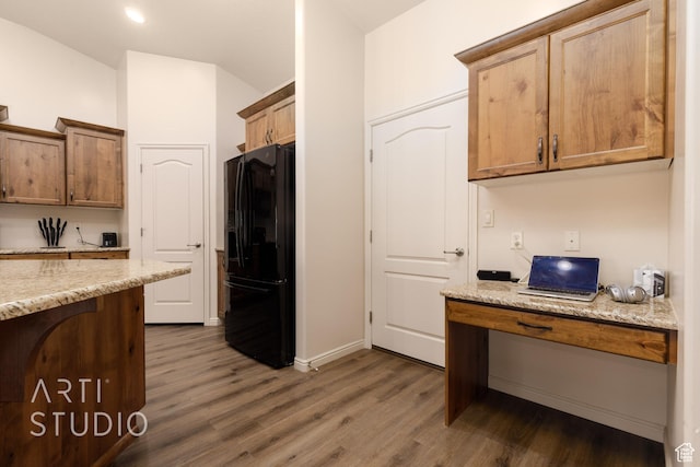 3504 E 3140 S, St George, UT 84790 - kitchen with black fridge, dark wood-type flooring, vaulted ceiling, light stone countertops, and baseboards