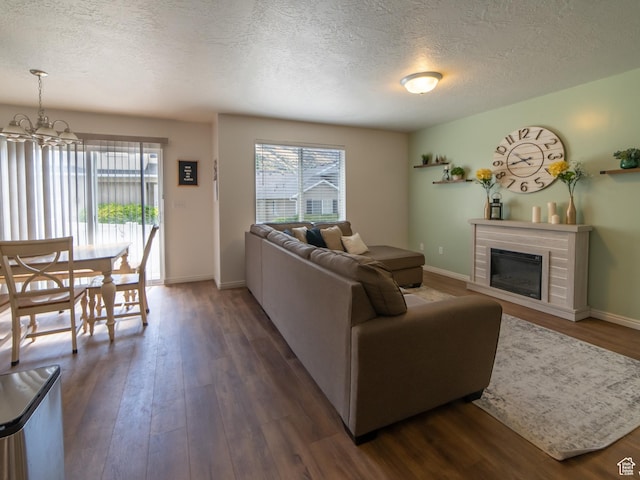1305 S 1410 E, Provo, UT 84606 - living area with healthy amount of natural light, a textured ceiling, dark wood-type flooring, a glass covered fireplace, and a chandelier
