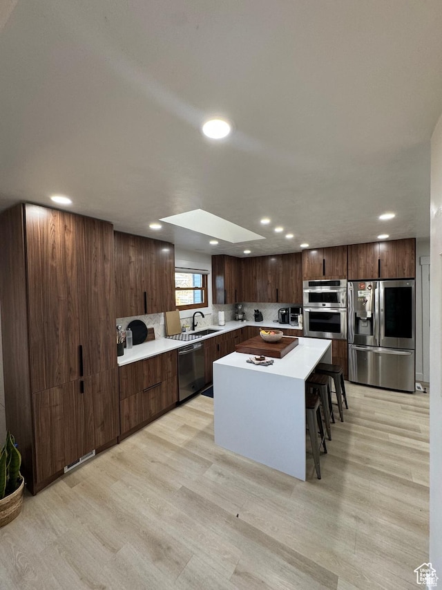 4288 S Shirley Ln, Holladay, UT 84124 - kitchen featuring appliances with stainless steel finishes, a sink, light wood-style floors, recessed lighting, and light countertops