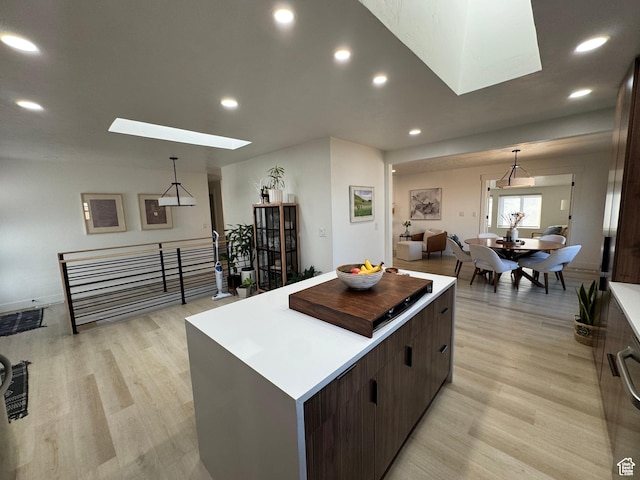4288 S Shirley Ln, Holladay, UT 84124 - kitchen featuring a skylight, a kitchen island, light wood finished floors, recessed lighting, and pendant lighting