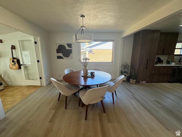 4288 S Shirley Ln, Holladay, UT 84124 - dining space featuring light wood-style flooring, a textured ceiling, and baseboards