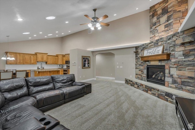 10605 S Willow Valley Rd W, South Jordan, UT 84095 - living room featuring a stone fireplace, light colored carpet, high vaulted ceiling, a ceiling fan, and arched walkways
