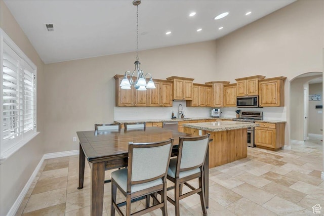 10605 S Willow Valley Rd W, South Jordan, UT 84095 - kitchen with appliances with stainless steel finishes, baseboards, high vaulted ceiling, a sink, and arched walkways