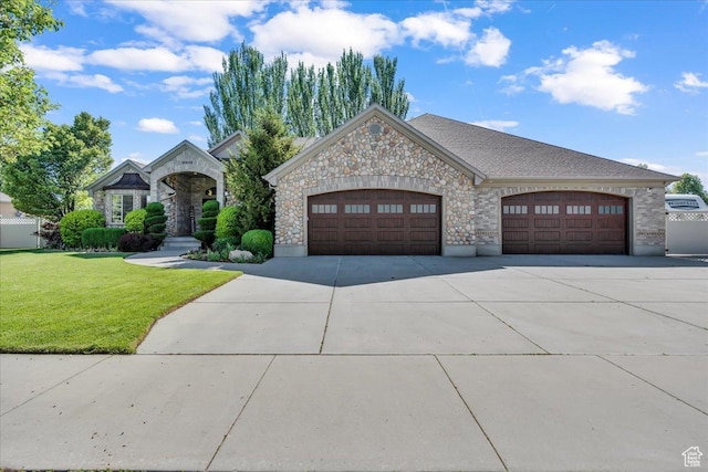 10605 S Willow Valley Rd W, South Jordan, UT 84095 - french country style house featuring concrete driveway, a front yard, an attached garage, and stone siding