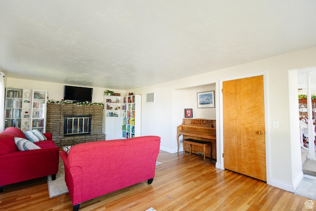 374 W Melba Dr S, Tooele, UT 84074 - living area featuring light wood finished floors, a brick fireplace, and baseboards