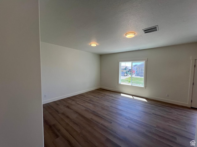 1154 E 1150 S, Garland, UT 84312 - unfurnished room with baseboards, dark wood finished floors, and a textured ceiling
