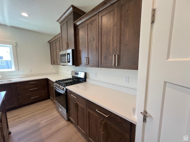 1154 E 1150 S, Garland, UT 84312 - kitchen with appliances with stainless steel finishes, light wood-type flooring, dark brown cabinetry, light countertops, and recessed lighting