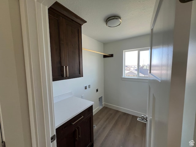 1154 E 1150 S, Garland, UT 84312 - laundry area featuring hookup for an electric dryer, cabinet space, dark wood-type flooring, a textured ceiling, and baseboards