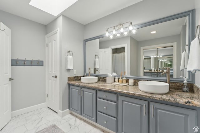 12214 S Hidden Valley Rd, Sandy, UT 84092 - full bathroom with a skylight, double vanity, marble finish flooring, and baseboards