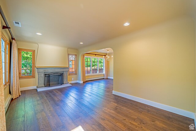 1820 E Redondo Ave S, Salt Lake City, UT 84108 - unfurnished living room with arched walkways, plenty of natural light, dark wood finished floors, baseboard heating, and recessed lighting