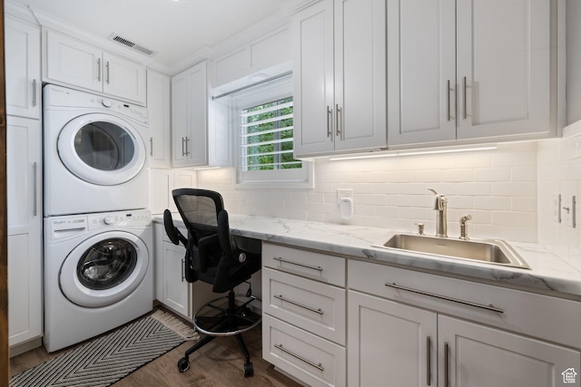 2137 E 170th Cir S, St George, UT 84790 - laundry room featuring stacked washer / dryer, cabinet space, and wood finished floors