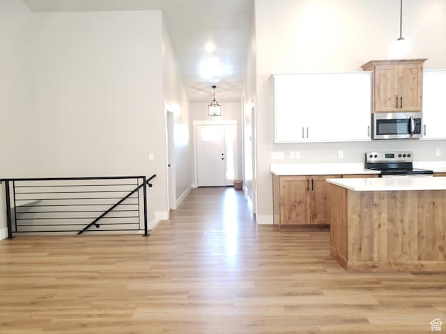 3425 W Isabel Way, West Haven, UT 84401 - kitchen with stainless steel appliances, light wood-style flooring, light countertops, decorative light fixtures, and baseboards