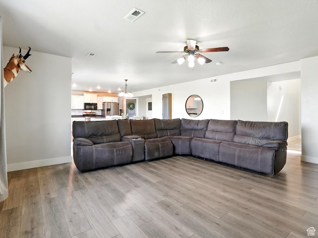 2699 N 3475 W, Plain City, UT 84404 - living room with ceiling fan, light wood-style flooring, a chandelier, and baseboards
