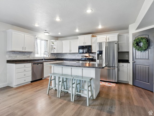 2699 N 3475 W, Plain City, UT 84404 - kitchen featuring stainless steel appliances, white cabinetry, a sink, tasteful backsplash, and a textured ceiling