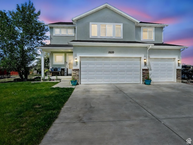 2699 N 3475 W, Plain City, UT 84404 - traditional home with an attached garage, stucco siding, a lawn, concrete driveway, and stone siding