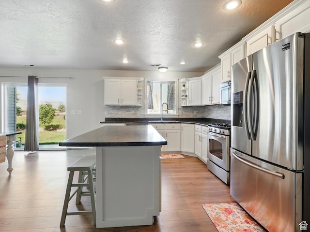 2699 N 3475 W, Plain City, UT 84404 - kitchen featuring appliances with stainless steel finishes, open shelves, dark countertops, a textured ceiling, and a sink