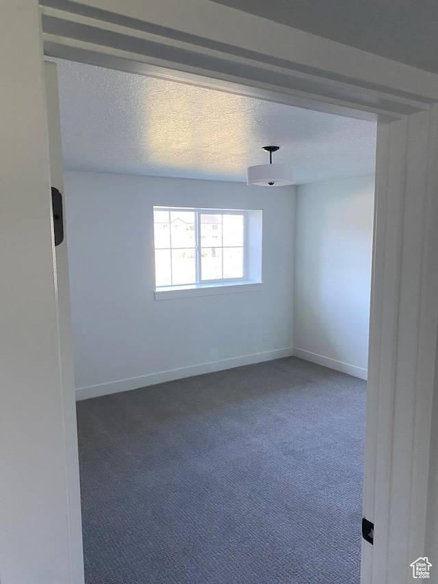 4618 W 75 N Unit 404, West Point, UT 84015 - spare room featuring carpet, baseboards, and a textured ceiling
