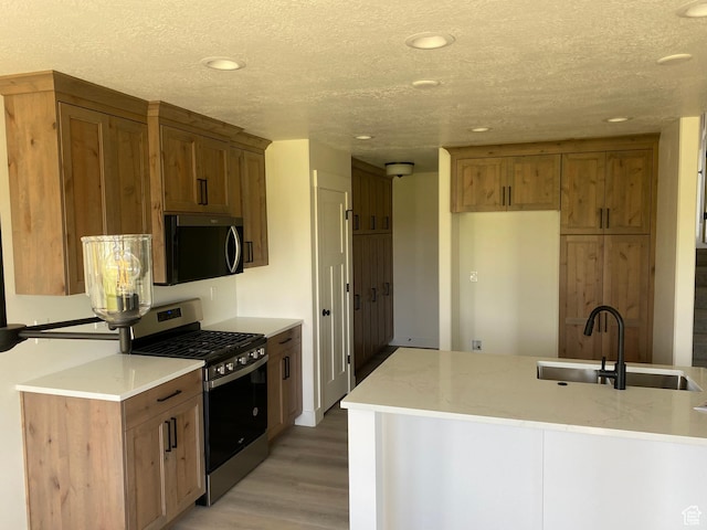 4618 W 75 N Unit 404, West Point, UT 84015 - kitchen featuring stainless steel appliances, a sink, light wood finished floors, recessed lighting, and brown cabinetry