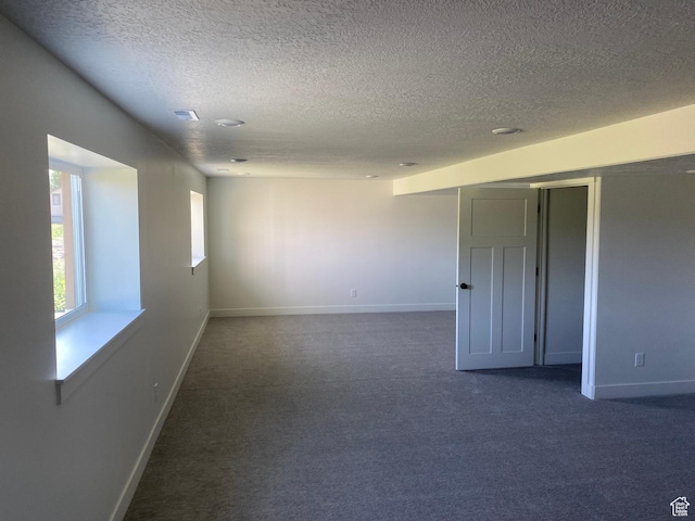 4618 W 75 N Unit 404, West Point, UT 84015 - spare room featuring a textured ceiling, dark carpet, and baseboards