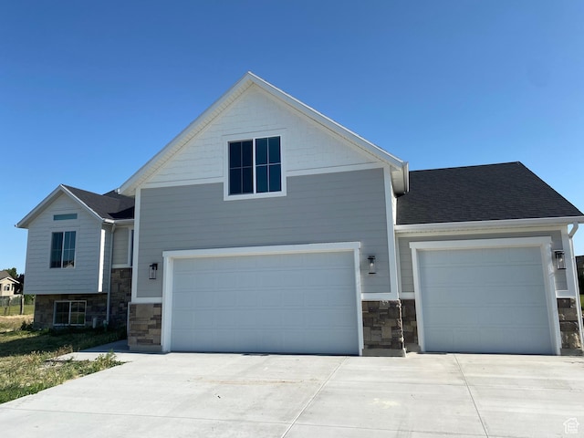 4618 W 75 N Unit 404, West Point, UT 84015 - view of front of house with stone siding, concrete driveway, and an attached garage