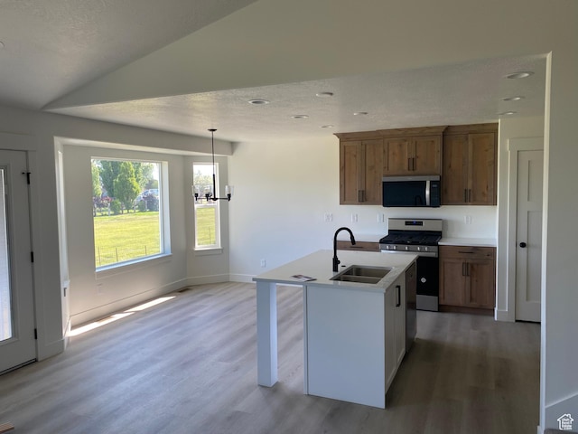 4618 W 75 N Unit 404, West Point, UT 84015 - kitchen with a sink, stainless steel appliances, light wood-style floors, a center island with sink, and light countertops