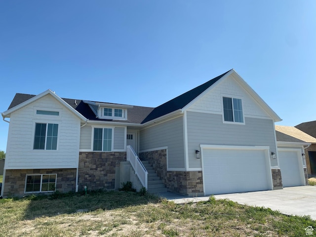 4618 W 75 N Unit 404, West Point, UT 84015 - view of front of house featuring stone siding, an attached garage, and concrete driveway