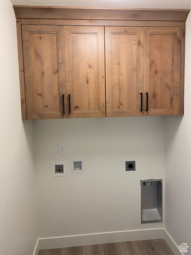 4618 W 75 N Unit 404, West Point, UT 84015 - laundry area with electric dryer hookup, cabinet space, baseboards, hookup for a washing machine, and wood finished floors