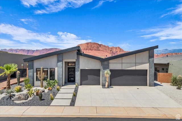 133 E Terrace Ln, Ivins, UT 84738 - modern home featuring a garage, a mountain view, driveway, and stucco siding