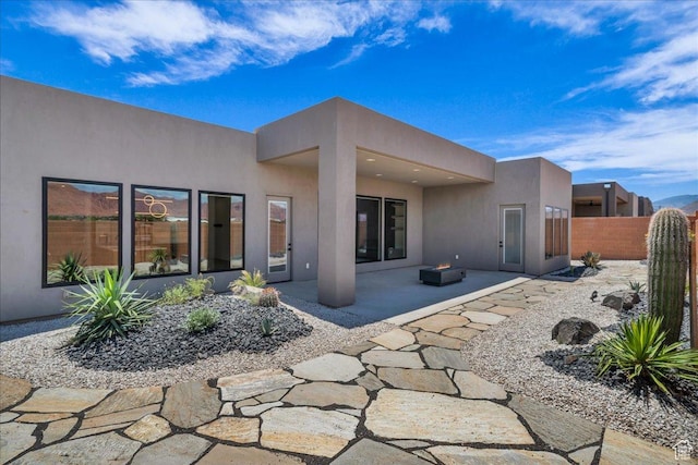 133 E Terrace Ln, Ivins, UT 84738 - rear view of property featuring stucco siding, a patio area, and an outdoor fire pit