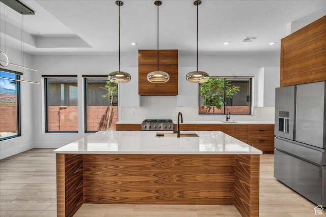133 E Terrace Ln, Ivins, UT 84738 - kitchen with stainless steel fridge, modern cabinets, brown cabinets, a sink, and light countertops