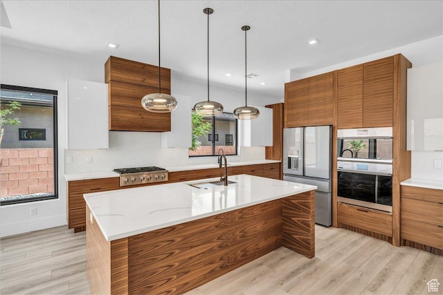 133 E Terrace Ln, Ivins, UT 84738 - kitchen with stainless steel appliances, brown cabinets, a sink, light wood-style floors, and recessed lighting
