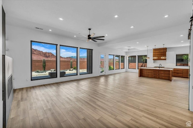 133 E Terrace Ln, Ivins, UT 84738 - unfurnished living room with a sink, plenty of natural light, light wood-style floors, a ceiling fan, and recessed lighting