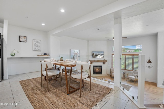 5521 N Freestyle Way, Park City, UT 84098 - dining space with light tile patterned floors, a glass covered fireplace, a ceiling fan, recessed lighting, and baseboards