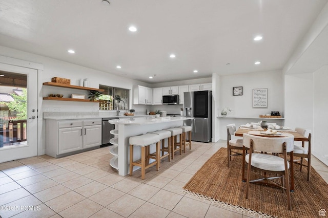 5521 N Freestyle Way, Park City, UT 84098 - kitchen with stainless steel appliances, light countertops, light tile patterned flooring, a kitchen bar, and open shelves
