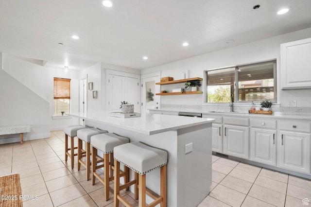 5521 N Freestyle Way, Park City, UT 84098 - kitchen with a center island, a breakfast bar area, white cabinetry, light tile patterned flooring, and open shelves