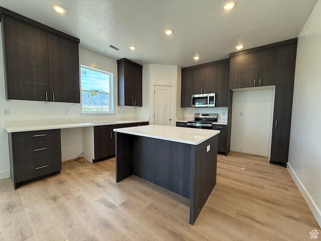 3298 S 1000 W, Nibley, UT 84321 - kitchen with appliances with stainless steel finishes, light wood-type flooring, light countertops, baseboards, and a kitchen island