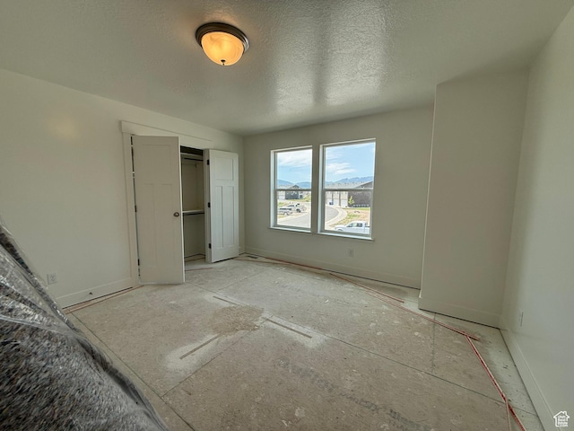 3298 S 1000 W, Nibley, UT 84321 - unfurnished bedroom with a closet, baseboards, and a textured ceiling